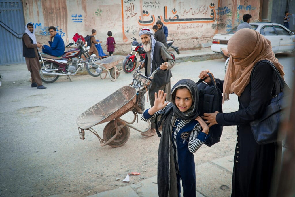 An Afghan mother helps her girl preparing to go to school. (before the Taliban take over the country)